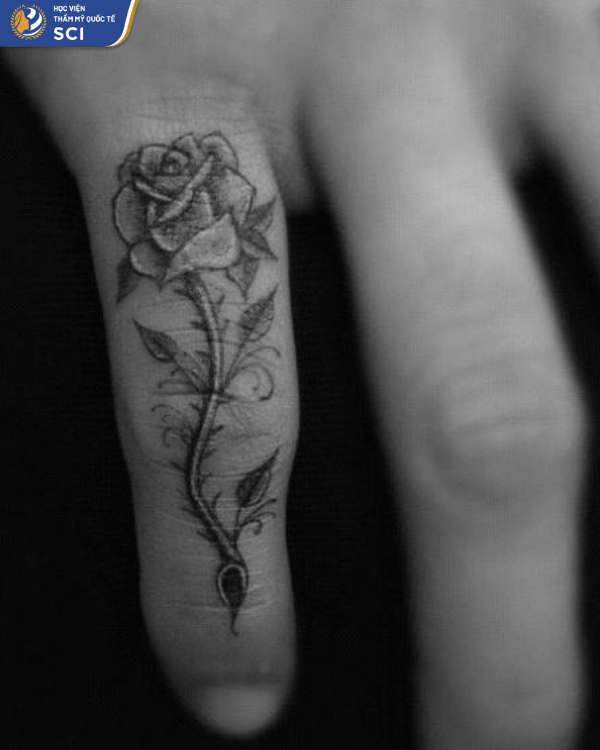 Một bông hồng gai góc ở ngón tay út như nhắc nhở về cuộc sống đầy thương tổn và khó khăn đã trải qua để mạnh mẽ hơn - hoidapnails.com